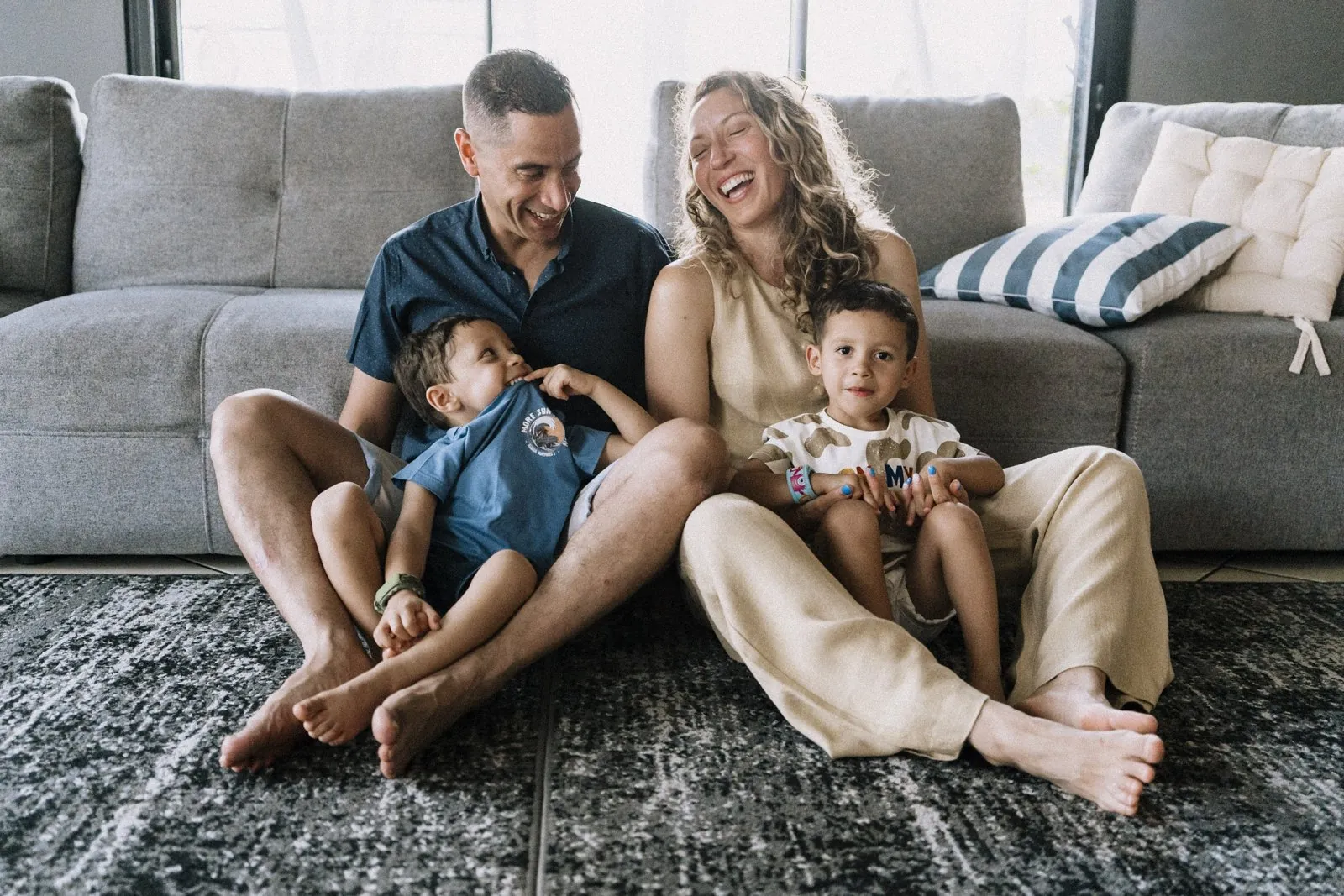 Toute la famille rit sur le canapé du salon