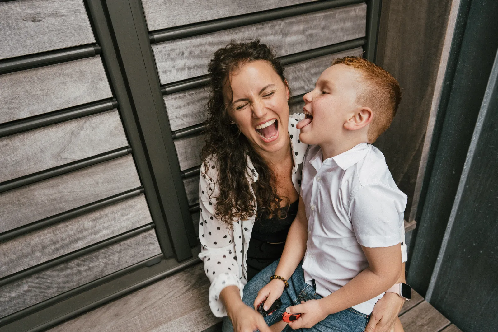 Une maman éclate de rire pendant que son fils lui lèche la joue